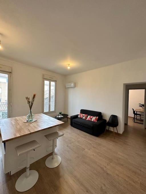 un salon avec une table et un canapé dans l'établissement Magnifique Appartement 2 chambres 60m2 Centre Ville Nîmes, à Nîmes