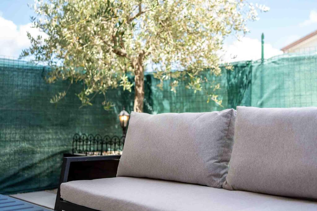 a couch sitting in front of a fence with a tree at Residenza l'Ulivo in Foiano della Chiana