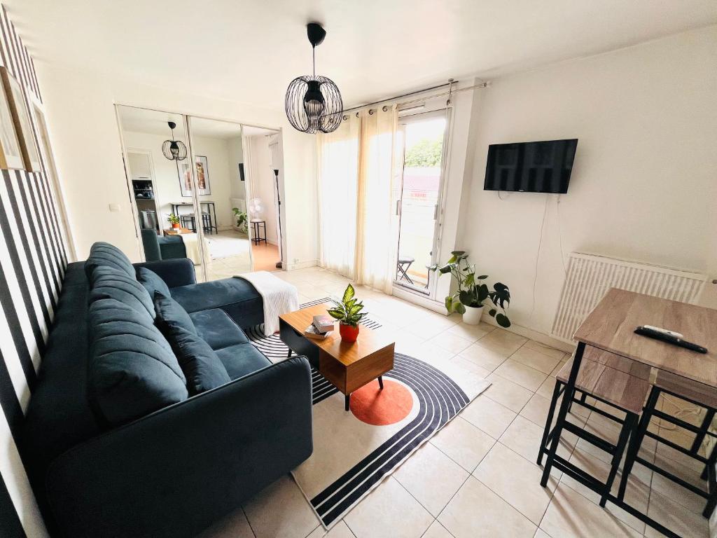 un salon avec un canapé et une table dans l'établissement COSY Apartment near the Center of Paris, Porte de Clichy, à Clichy
