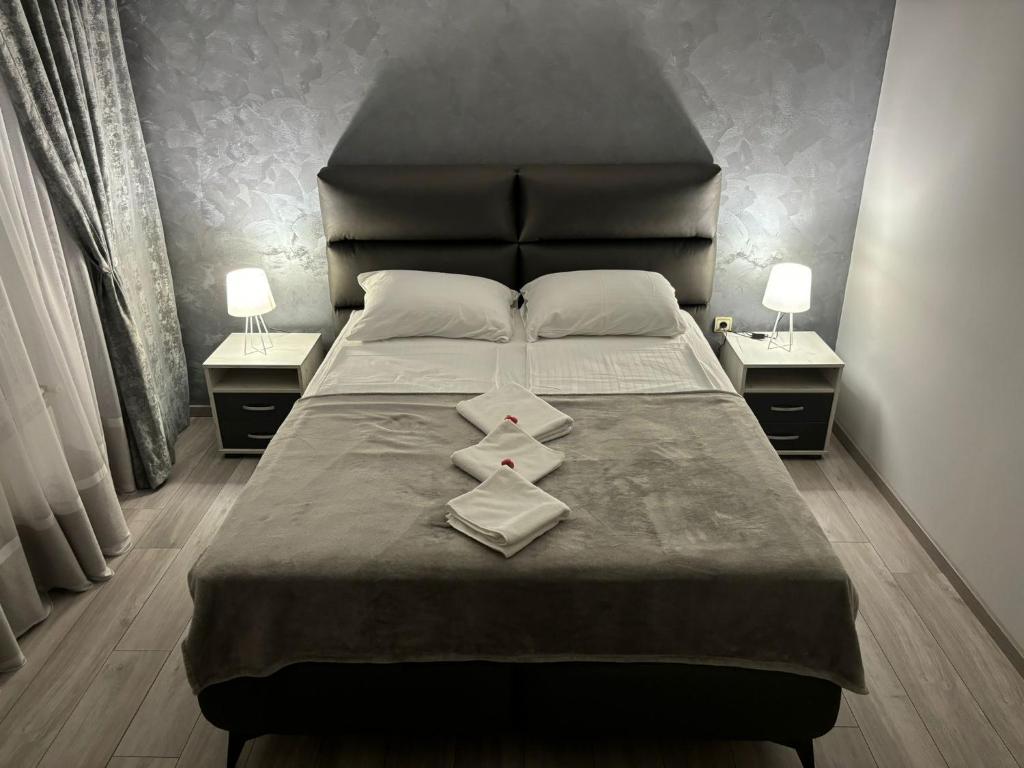 Un dormitorio con una cama grande con dos mesitas de noche. en Icy Apartment, en Belgrado