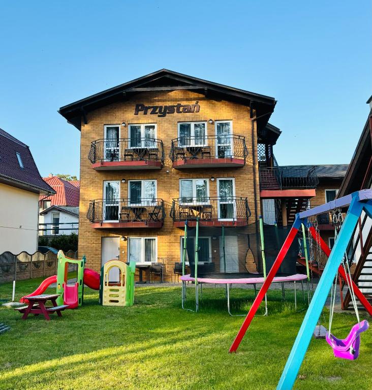 an apartment building with a playground in front of it at Dom Gościnny Przystań in Międzywodzie