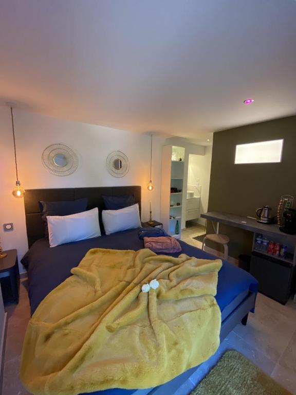 une chambre avec un lit avec une couverture dessus dans l'établissement La chambre d'hôte de la fontaine de Jonquier Jacuzzi privatif, à Séguret