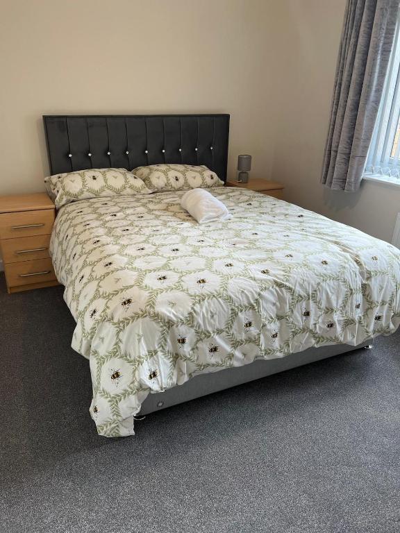 a bed with a white comforter with a pillow on it at Mesnes Place in Wigan