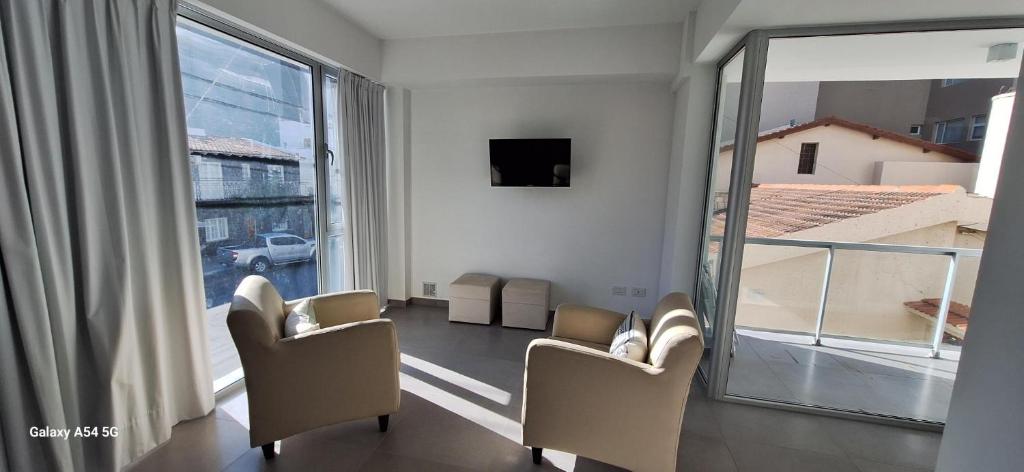 a room with two chairs and a large window at Amanecerpuertomadryn 1 in Puerto Madryn