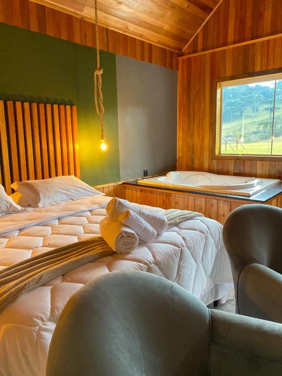 a bedroom with a bed with a teddy bear on it at Pousada Rural Pavão - Suites e Chalés in Urubici