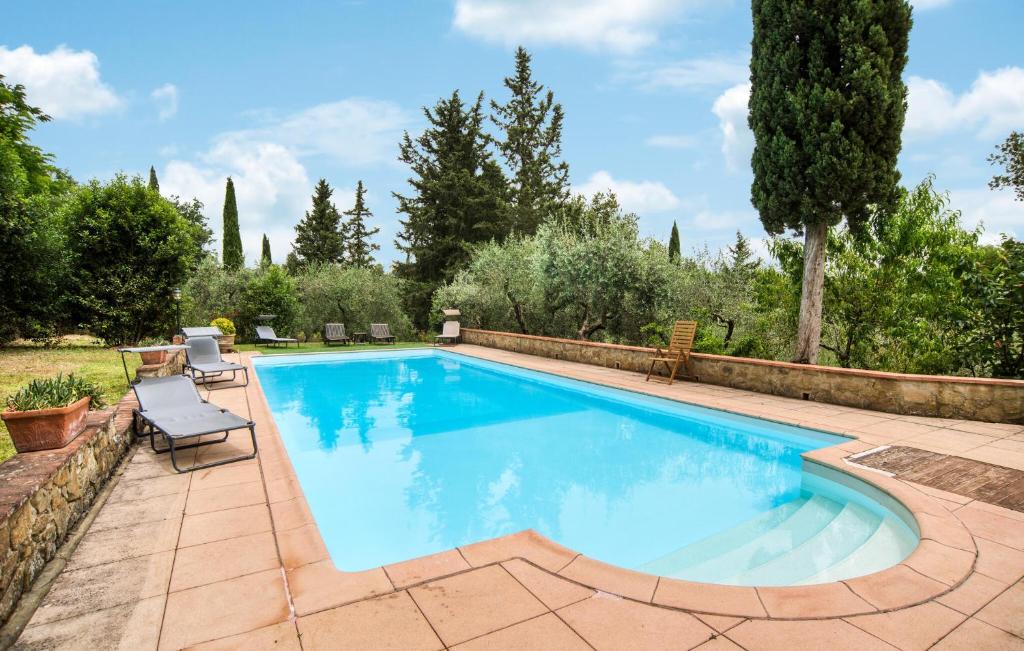 una piscina en un patio trasero con 2 sillas al lado en Il Loggiato, en Monte San Savino