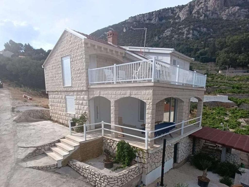 a large stone house with a balcony on top of it at Seaside holiday house Podobuce, Peljesac - 23460 in Orebić