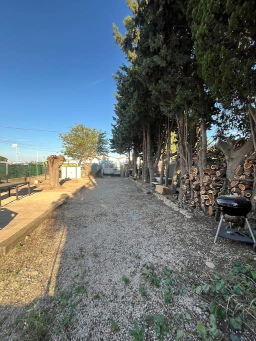 une route de gravier avec des arbres et un gril dessus dans l'établissement Haut de Villa, Jardin, Piscine !, à Fos-sur-Mer
