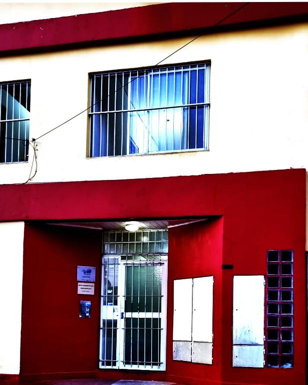 a red and white building with a red door at Apartamento POSADAS in Posadas
