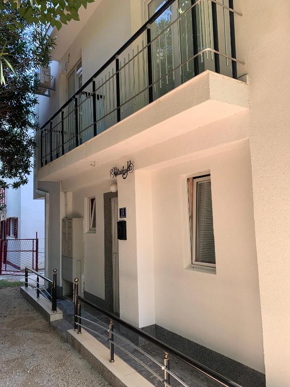 a white building with a balcony on it at LamijaApartmani in Sutomore