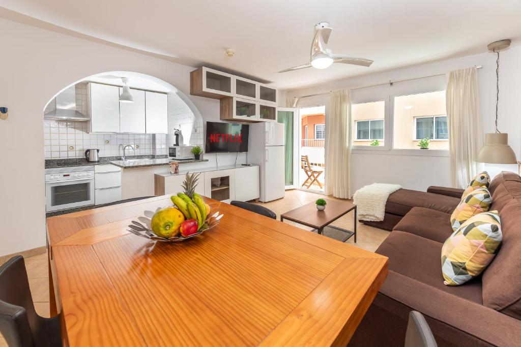 a living room with a couch and a table with a bowl of fruit at Calas Beach Corralejo in Corralejo