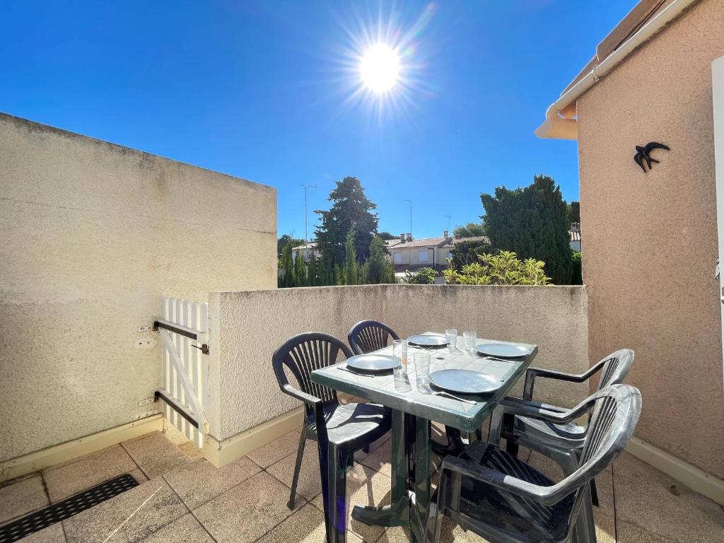 d'une table et de chaises sur un balcon bien exposé. dans l'établissement Appart cosy avec terrasse à 500m de la plage, parking, animaux admis, quartier dynamique - Sète - FR-1-338-494, à Sète