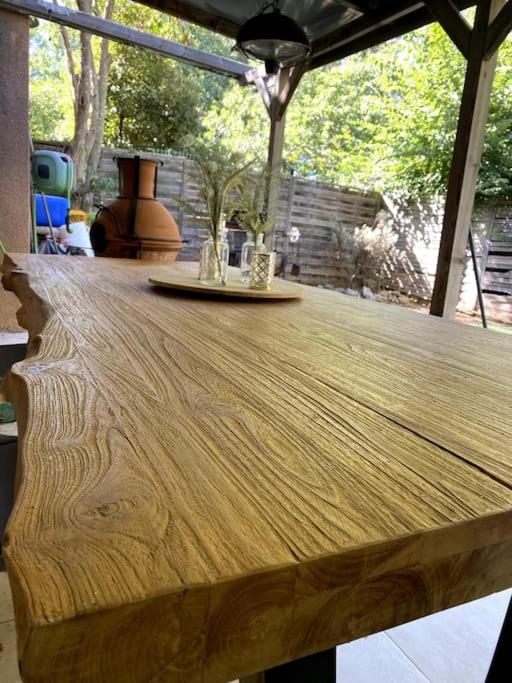une table en bois avec deux verres au-dessus dans l'établissement Maison familiale et spacieuse, à Montpellier
