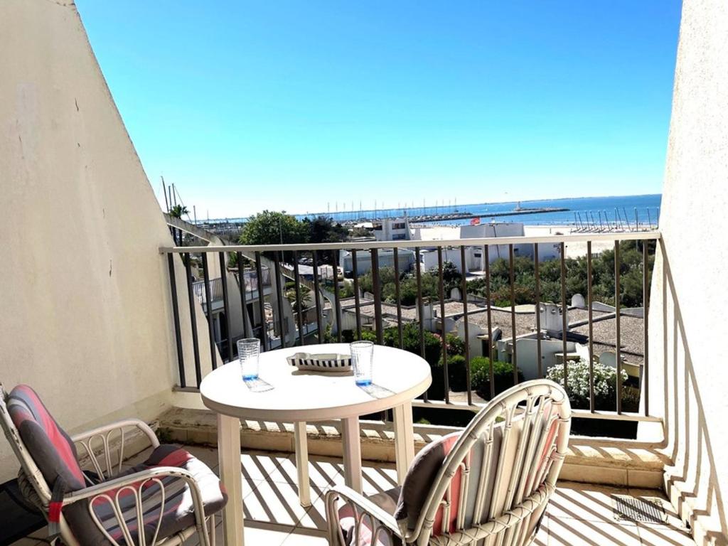 un balcon avec une table et des chaises et une vue sur la plage dans l'établissement Studio cabine à La Grande Motte, 4 couchages, parking, proche commerces et plage - FR-1-790-31, à La Grande Motte