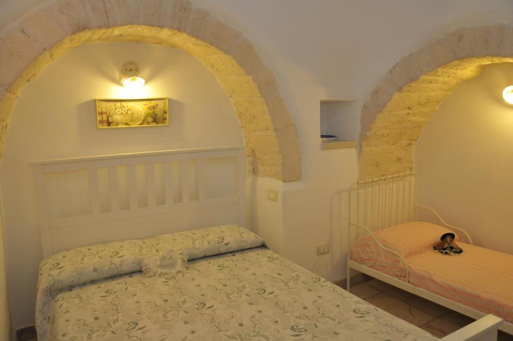 una piccola camera con letto e arco di Trullo Relax ad Alberobello