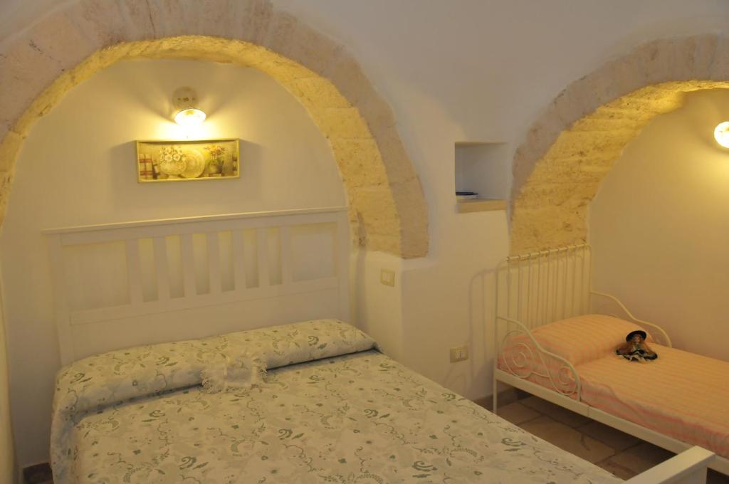 アルベロベッロにあるTrullo Relaxの小さなベッドルーム(ベッド1台、アーチ付)
