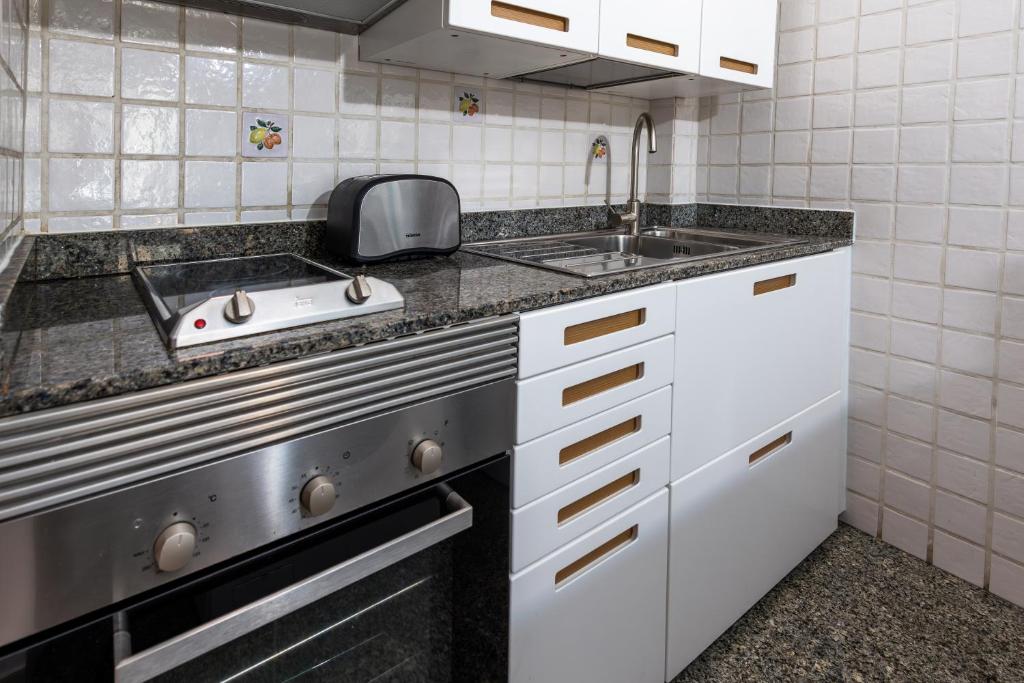 a small kitchen with a sink and a stove at Calas Beach Corralejo in Corralejo
