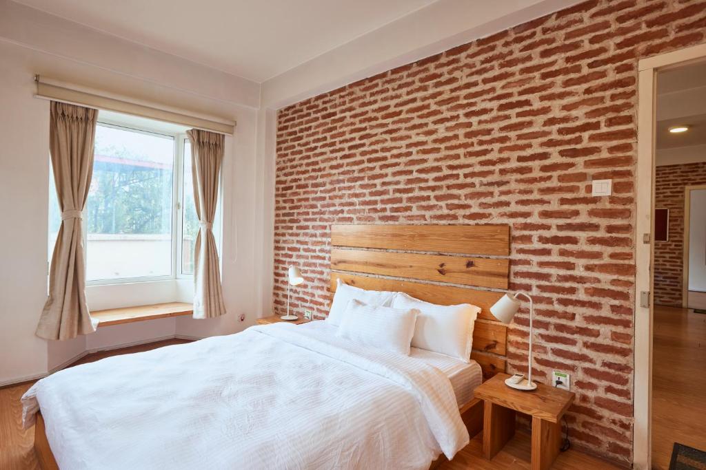 a bedroom with a brick wall and a bed at Ananya Apartments Phase 1 in Kathmandu