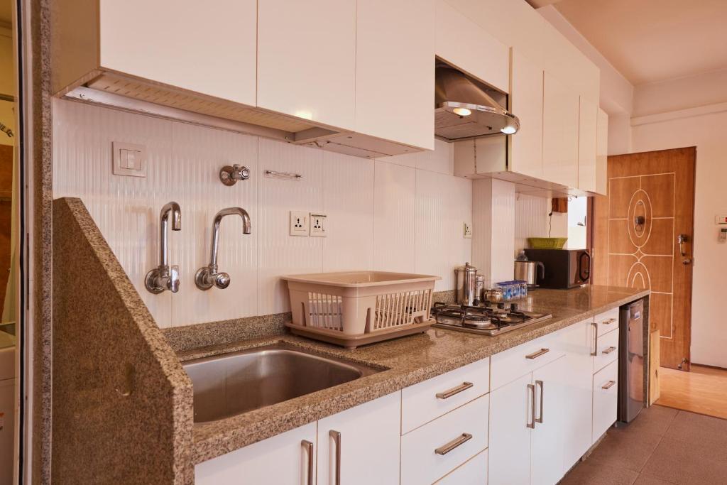 a kitchen with white cabinets and a sink at Ananya Apartments Phase 1 in Kathmandu