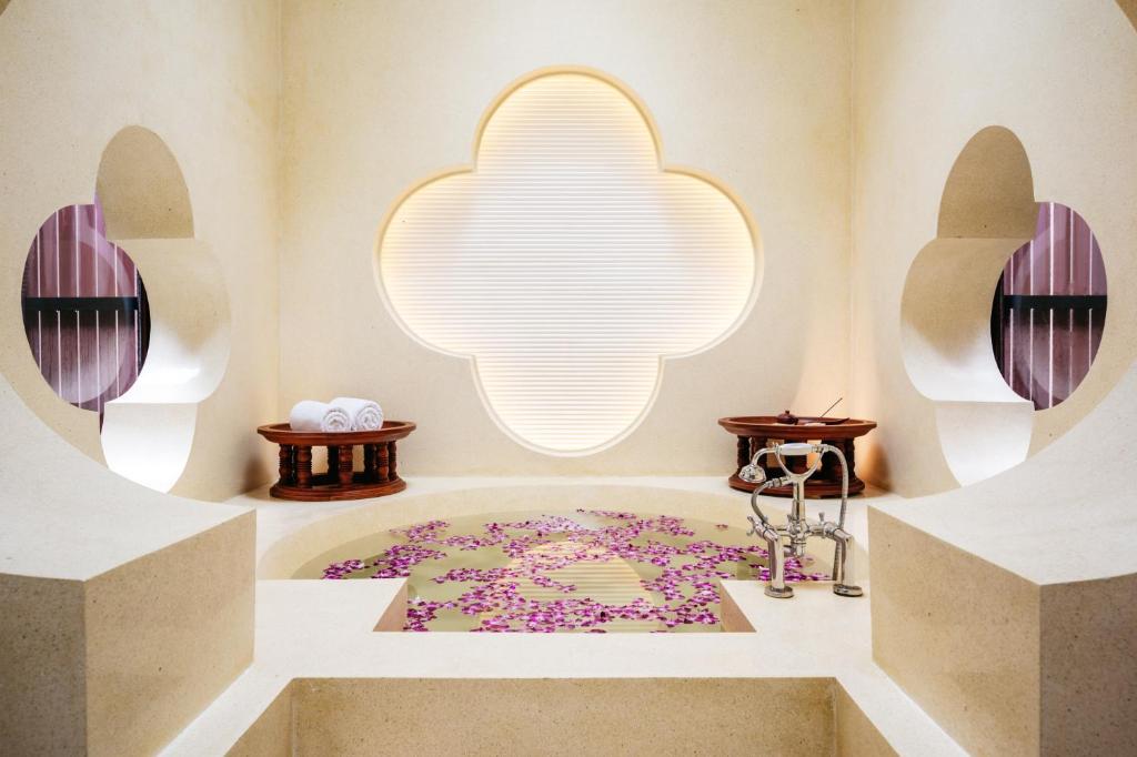 a bathroom with a bath tub with a large light fixture at Phulay Bay, A Ritz-Carlton Reserve in Tab Kaek Beach