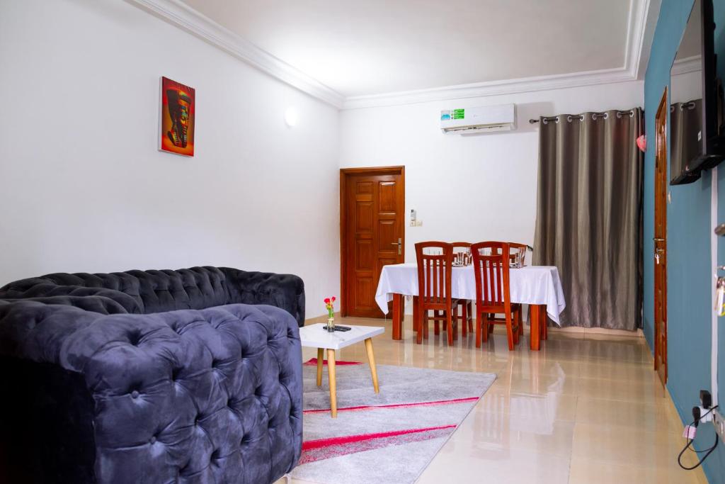 una sala de estar con un sofá y una mesa en JRéside Appart Bleu 50m2 centre-ville, en Cotonou