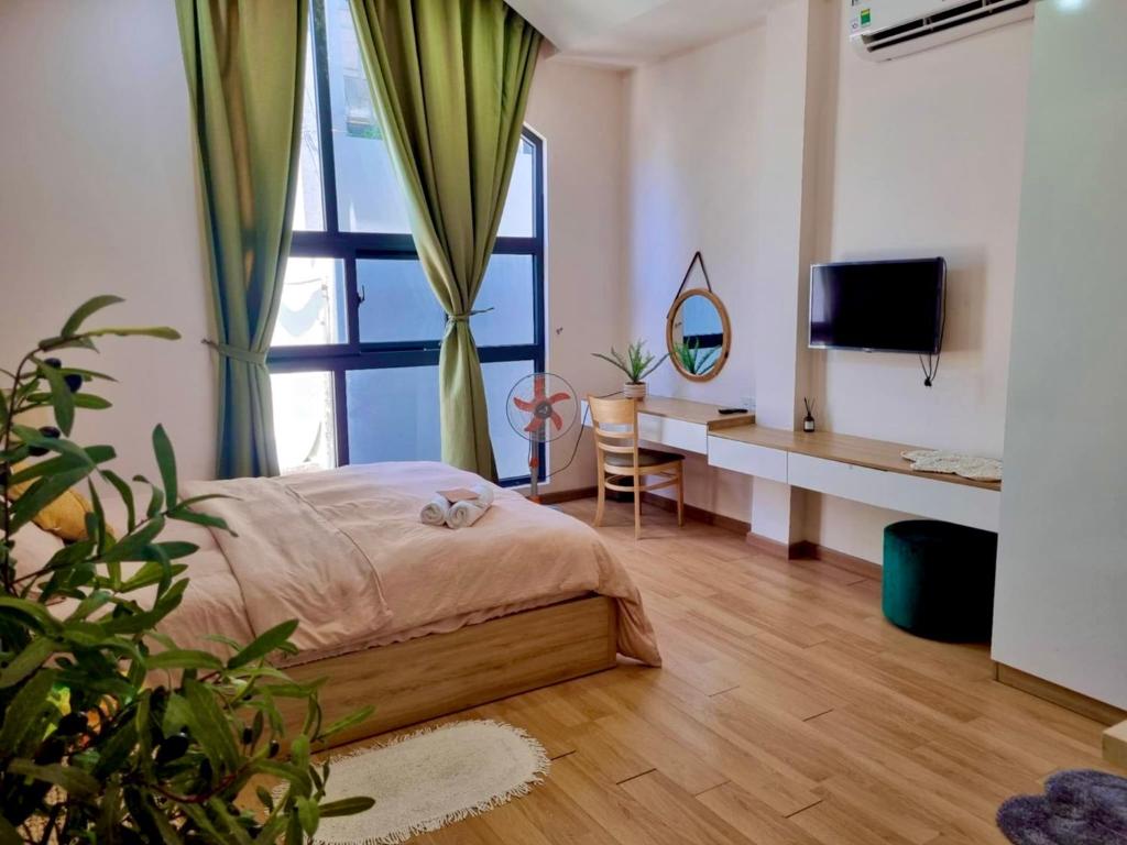 Un dormitorio con una cama y una ventana grande en Mango Home & Apartment, en Da Nang
