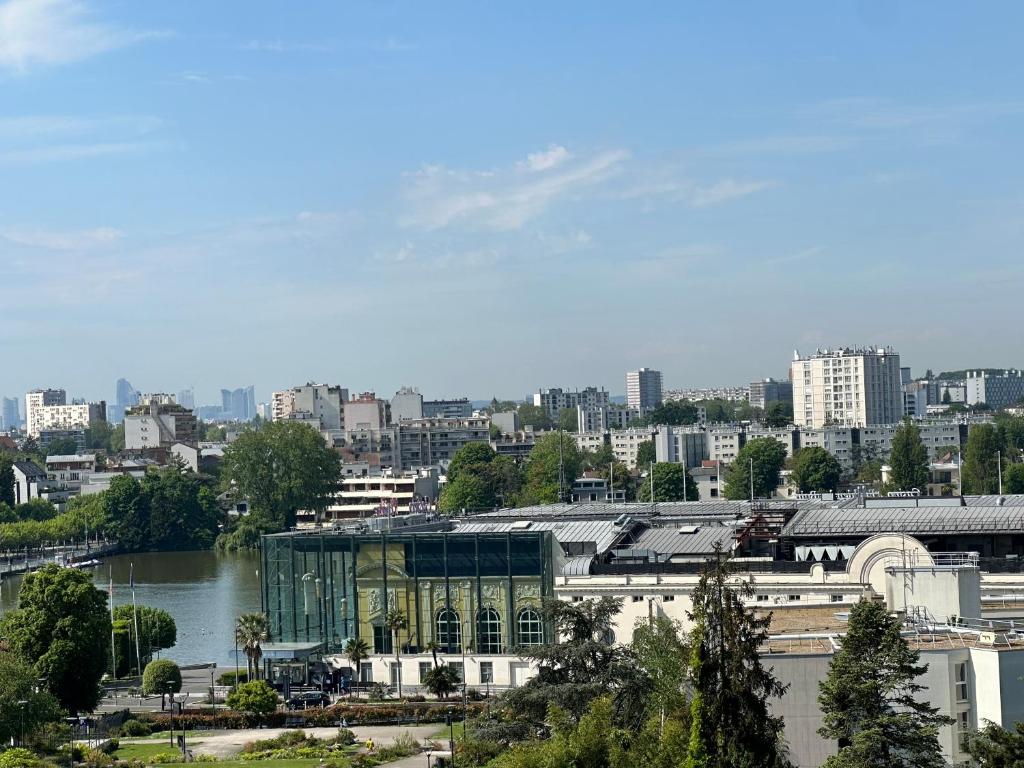 - une vue sur une ville avec un bâtiment et une rivière dans l'établissement Mora, à Enghien-les-Bains