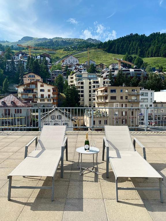 two white benches sitting on top of a roof at Crystal Hotel superior in St. Moritz