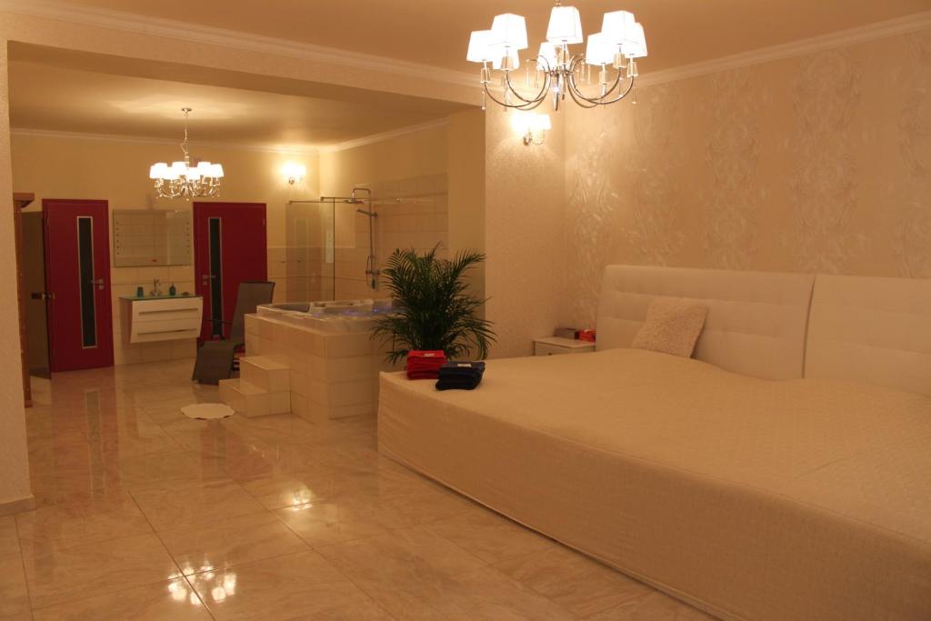 um quarto com uma grande cama branca e uma casa de banho em Penzion 4 Dvory em České Budějovice