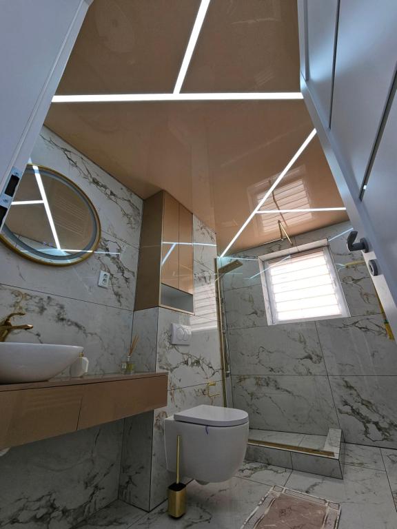 a bathroom with a toilet and a sink and a window at Filip residence in Cluj-Napoca