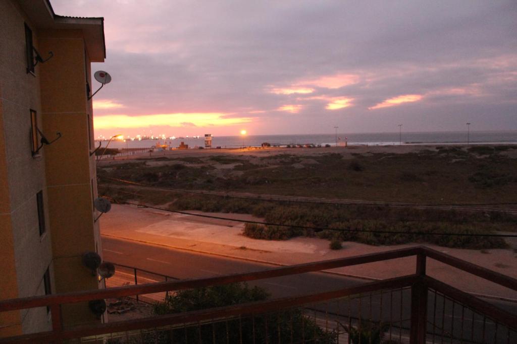 a view of the beach at sunset from the balcony of a building at Departamento Vistamar in Arica