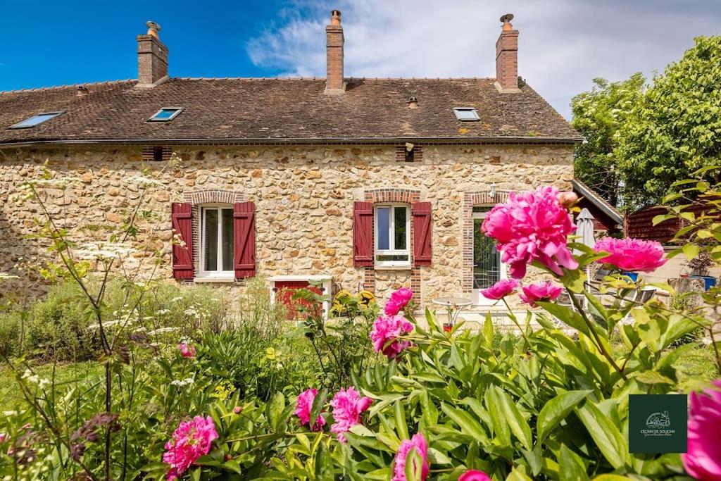 an old stone house with red shutters and pink flowers at L' Ecrin de Soligny gîte 5 personnes - parking et accès privatif in Soligny-les-Étangs