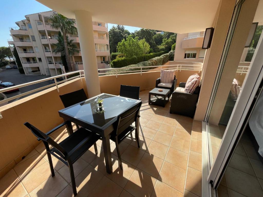 un balcon avec une table et des chaises sur un balcon dans l'établissement Les calanques, à Cavalaire-sur-Mer