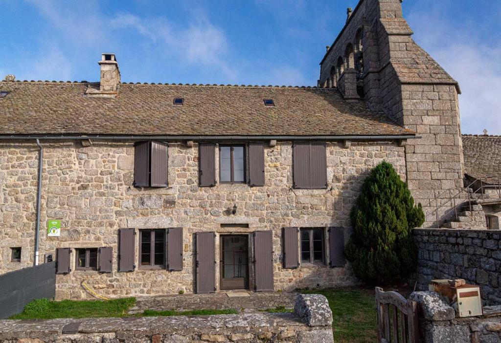 an old stone house with a chimney on top of it at Gites de france de la fage montivernoux in Saint-Laurent-de-Veyrès