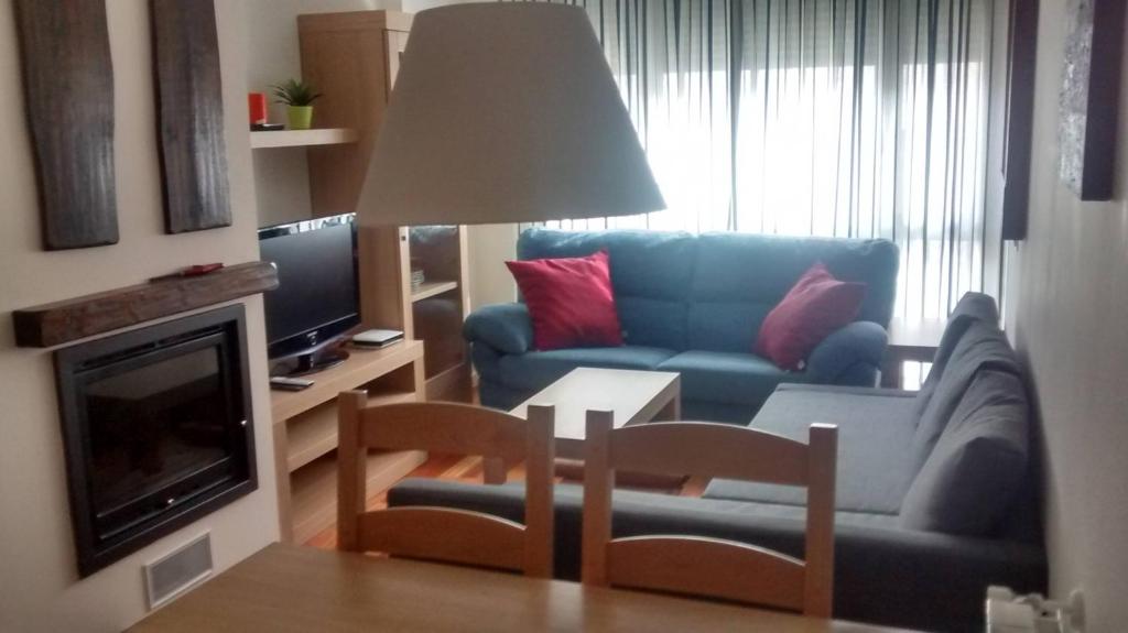a living room with a blue couch and a tv at Margas Golf Apartment in Latas