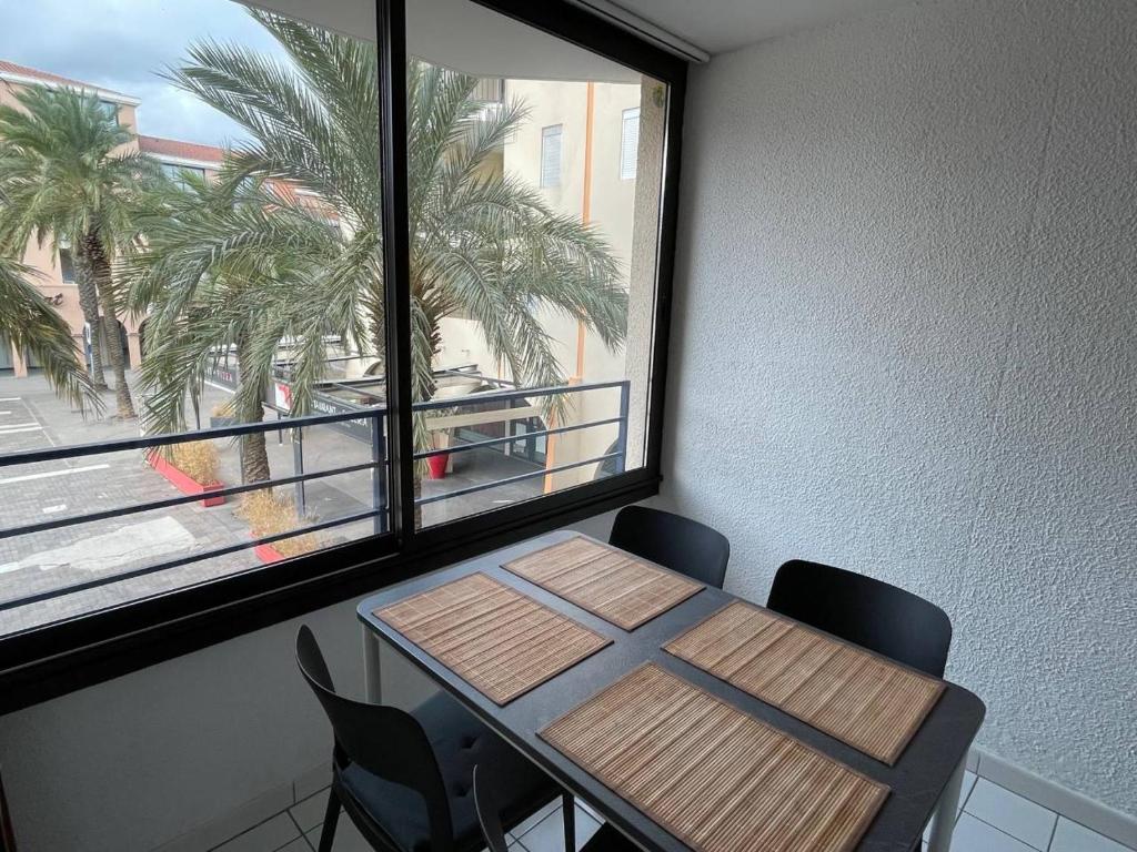 une table et des chaises dans une pièce avec une fenêtre dans l'établissement Appartement 2 pièces 4 couchages ARGELES SUR MER AR370-013, à Argelès-sur-Mer