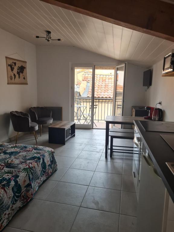 Cette chambre comprend un lit, une cuisine et une table. dans l'établissement Studio 2 étoiles 