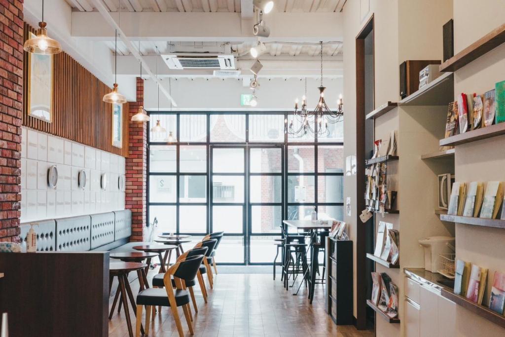 a dining room with tables and chairs and a large window at Hostel JAZ in Tokyo