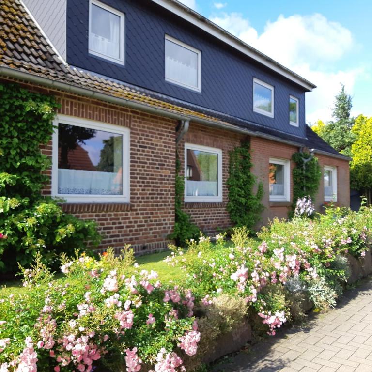a house with flowers in front of it at Nordseeferienhaus Peter in Niebüll