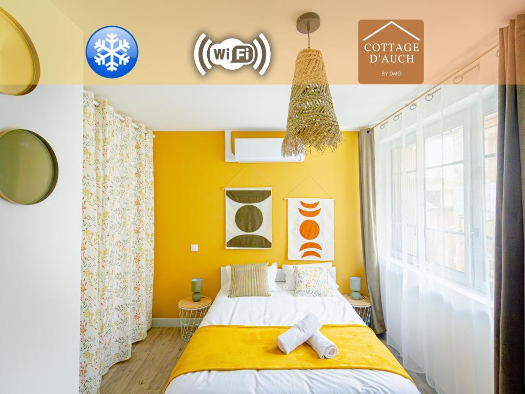 una camera da letto con un letto e una parete gialla di L'Indigo "By Cottage d'Auch" ad Auch