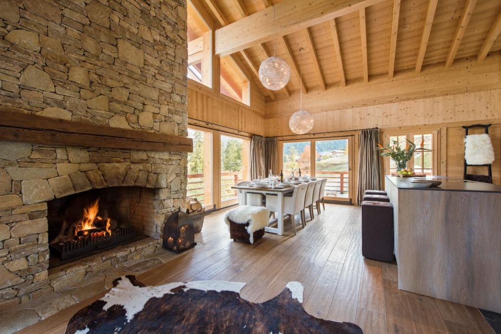 a living room with a stone fireplace and a table at Chalet Alexia in La Tzoumaz
