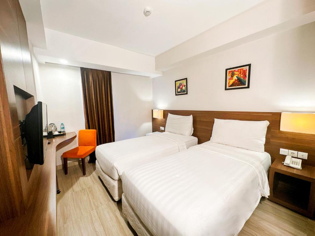 Postel nebo postele na pokoji v ubytování Next Hotel Yogyakarta