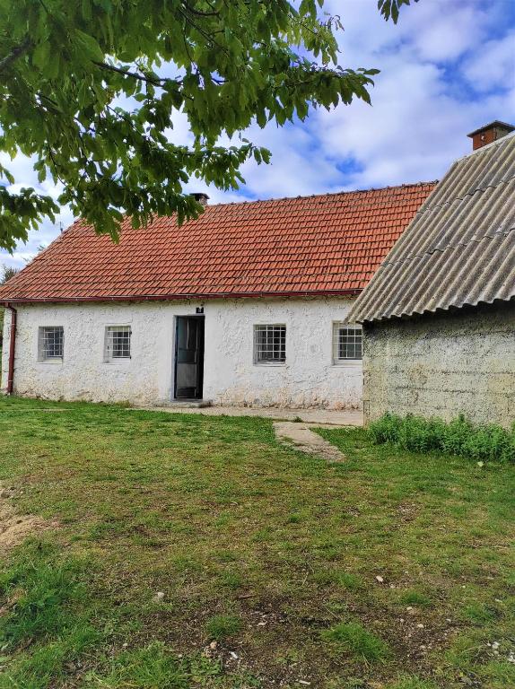 an old white building with a red roof at Stone house in Plužine
