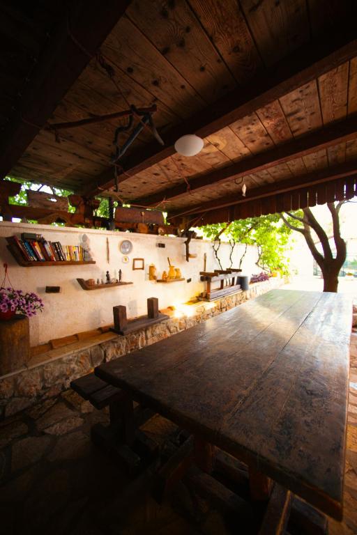 a large wooden table in a patio with a tree at Villa SHU in Krimovice