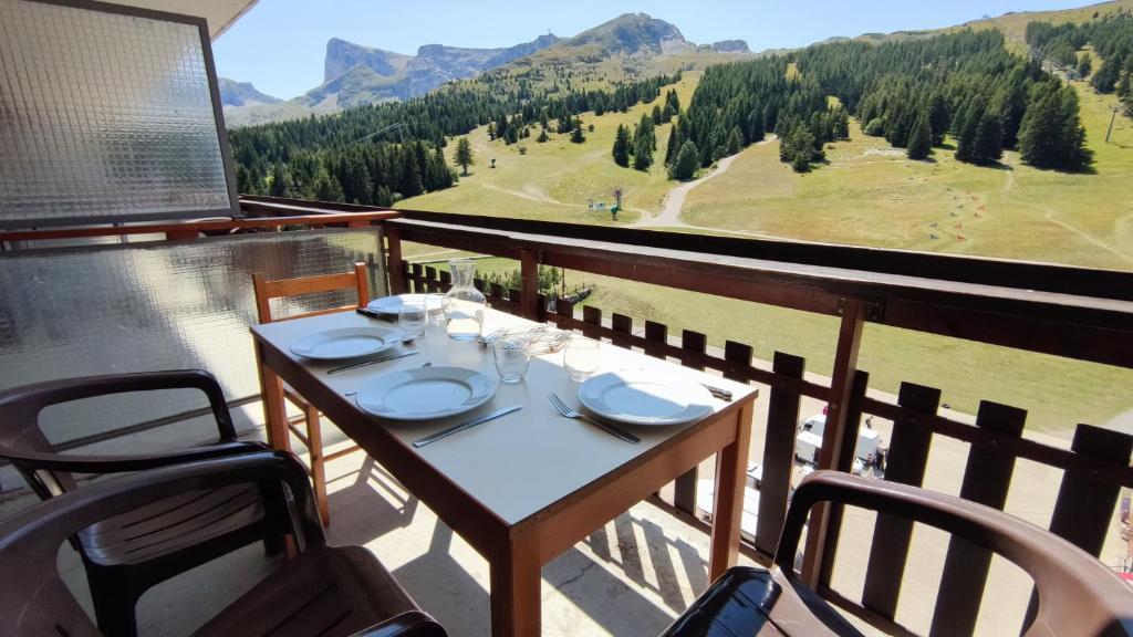 a table and chairs on a balcony with a view at Studio 4 personnes Sud rénové - pied des pistes in Superdevoluy