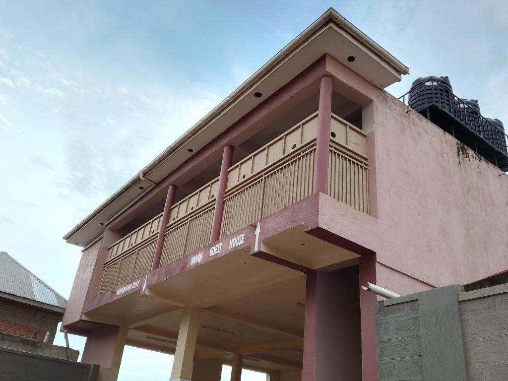 a building with a balcony on top of it at Wana Guest House in Rubirizi