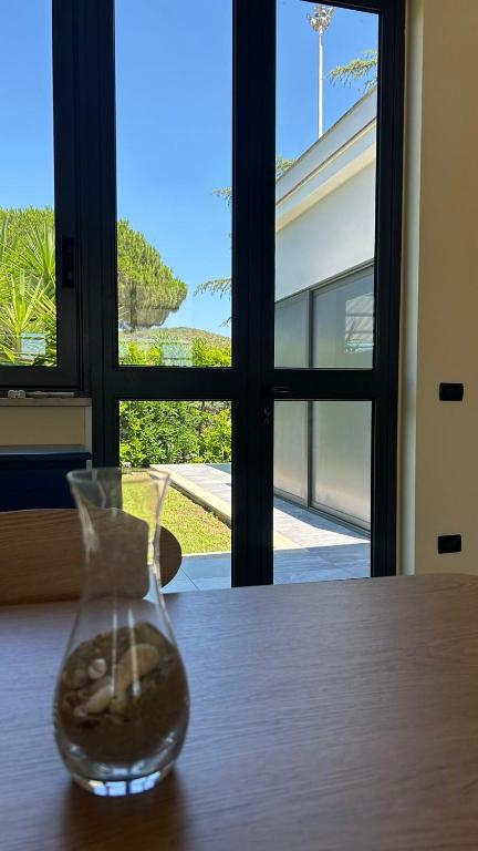 a glass vase sitting on a table with a window at La Flacca Rooms in Sperlonga