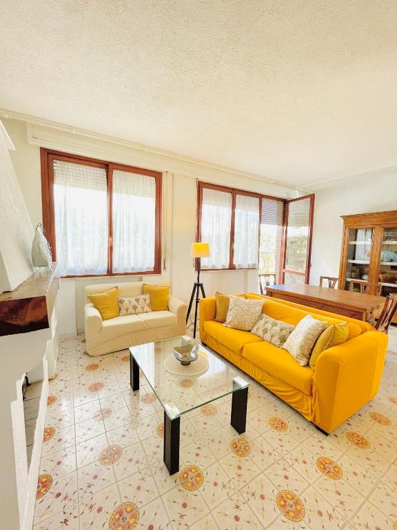 a living room with a yellow couch and a table at Casa Rea in Francavilla al Mare