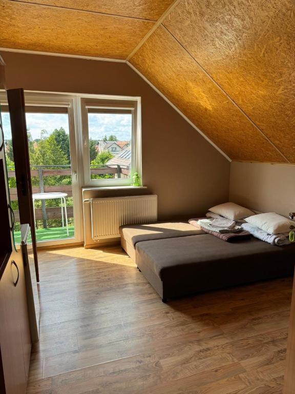 a bedroom with two beds and two windows at Zefirek in Stegna
