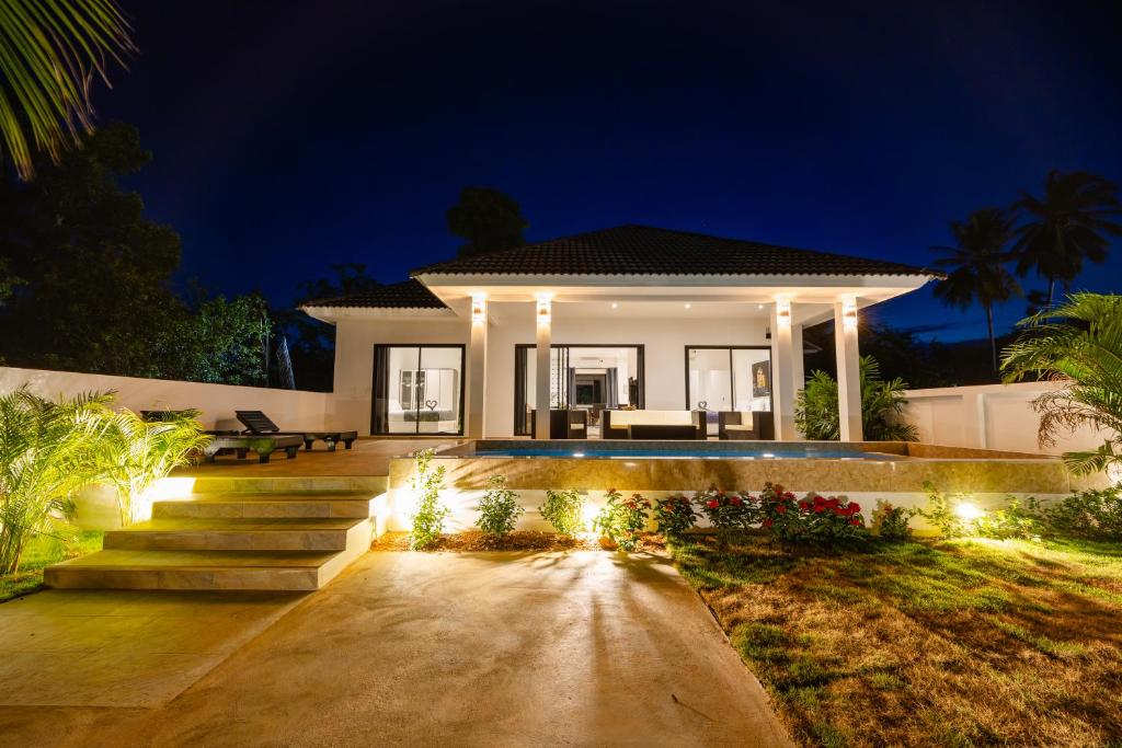 a house with lights in front of it at night at Thala Villa Koh Samui in Nathon Bay